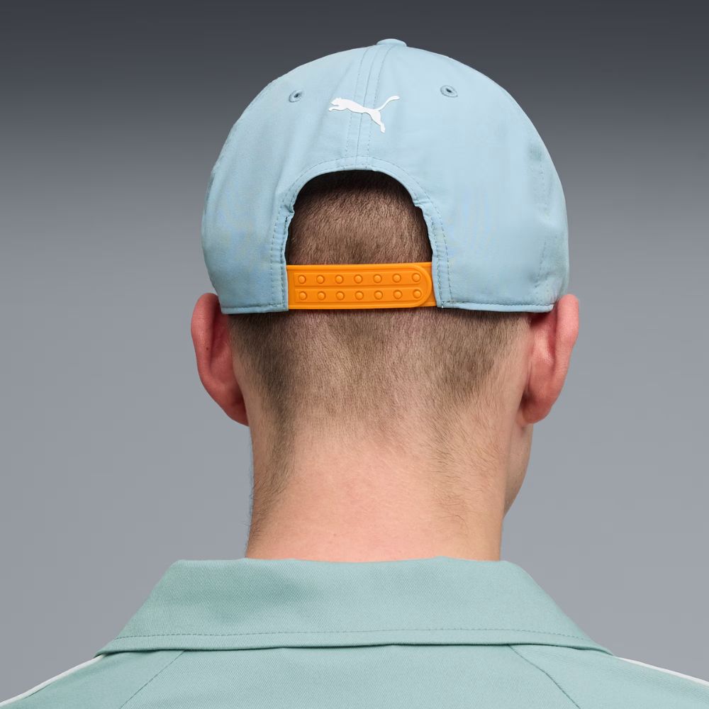 Modelo de espaldas usando jockey Puma McLaren Racing Seafoam con cierre ajustable naranjo de doble hilera