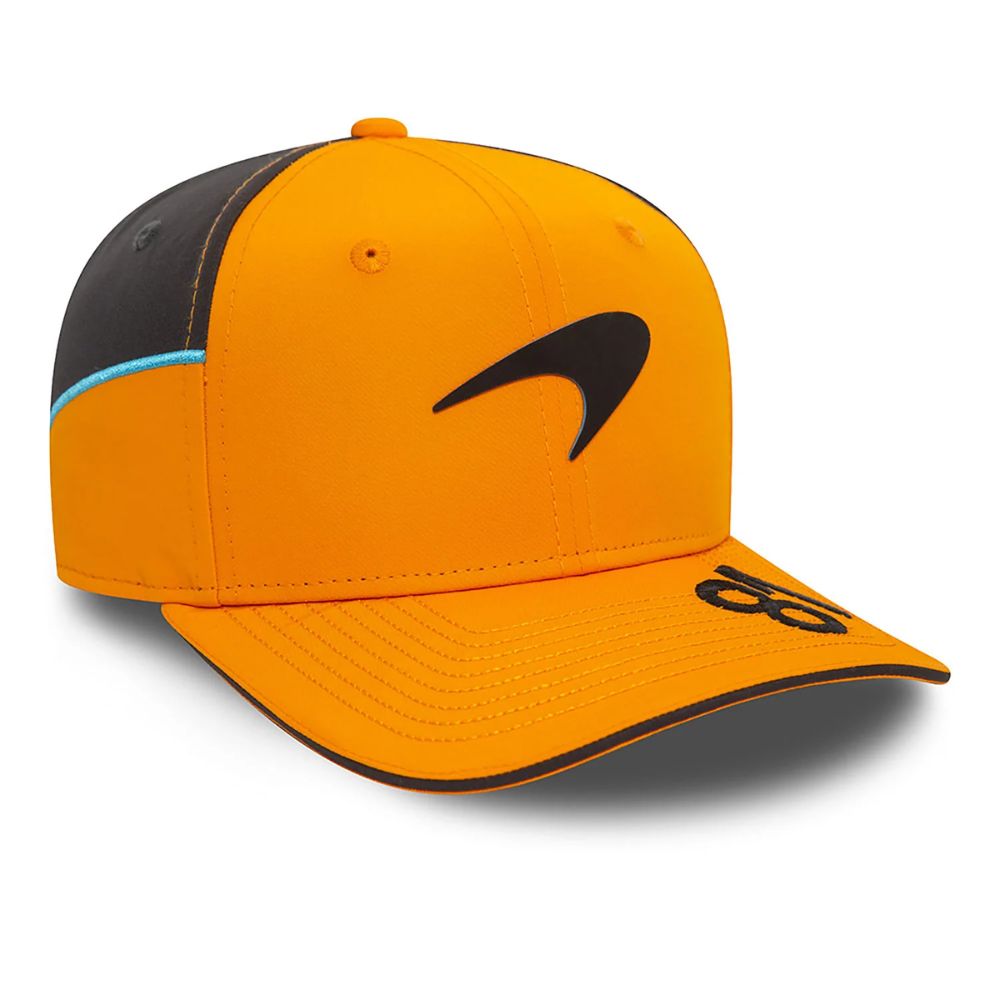 Jockey New Era McLaren Racing Oscar Piastri naranjo, vista diagonal con paneles negros y detalle celeste