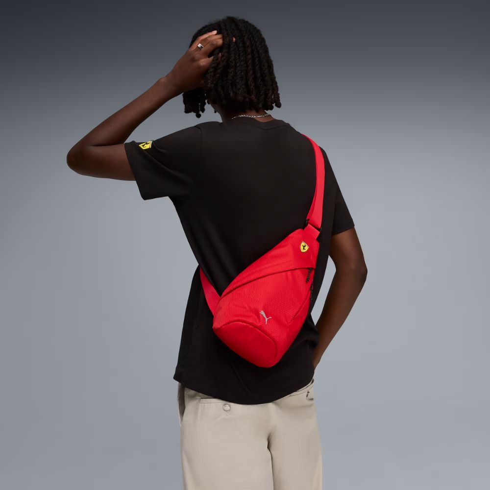 Persona usando mochila bandolera Puma Scuderia Ferrari roja cruzada sobre la espalda